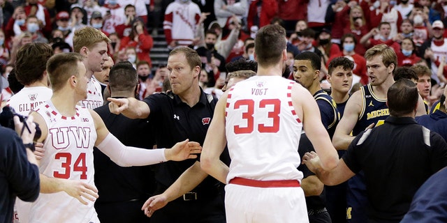 Wisconsin Badgers assistant coach Joe Krabbenhoft reacts after a fight breaks out between Wisconsin and the Michigan Wolverines. Krabbenhoft was hit in the head by Michigan head coach Juwan Howard at Kohl Center on Feb. 20, 2022, in Madison, Wisconsin.