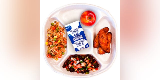This photo provided by the New York City Department of Education shows the Black Bean and Plantain Rice Bowl, green garden salad, salad bar carrot and lemon salad vegan school lunch. 