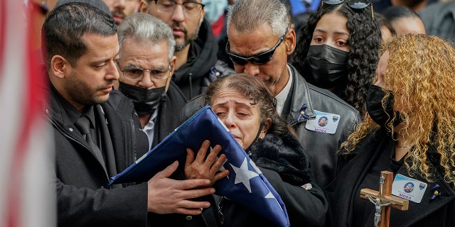Family members of NYPD Officer Wilbert Mora react after receiving a flag from the honor guard following Mora's funeral at St. Patrick's Cathedral, Feb. 2, 2022, in New York City.