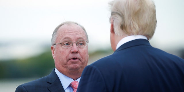 President Donald Trump talks with Minnesota 1st Congressional district Republican nominee Jim Hagedorn as the president arrives at Minneapolis – Saint Paul International Airport for nearby fundraising and campaigning in Minneapolis, Minnesota, Oct. 4, 2018.