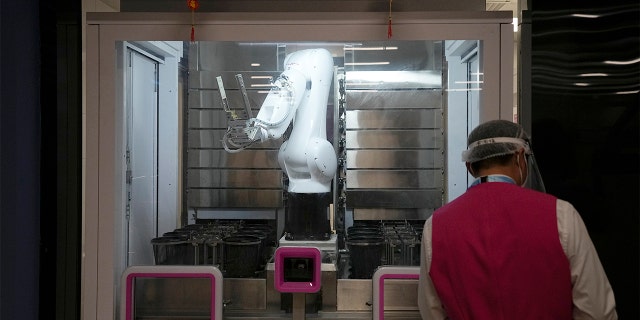 A robot prepares food in the media dining area of the main media center ahead of the 2022 Winter Olympics, Wednesday, Feb. 2, 2022, in Beijing.
