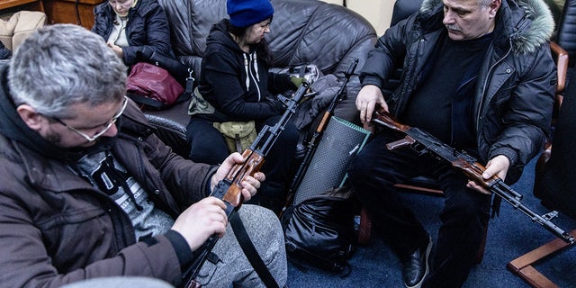 Voluntarios civiles revisan sus armas en una oficina de registro de la unidad de defensa territorial el 26 de febrero de 2022 en Kiev, Ucrania. 