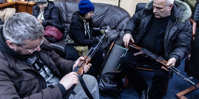 Civilian volunteers check their guns at a Territorial Defence unit registration office on February 26, 2022 in Kyiv, Ukraine.