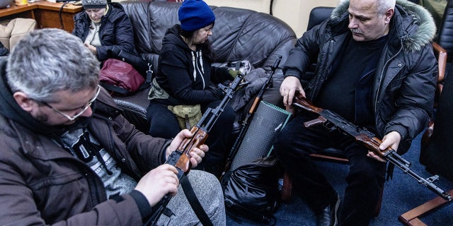 Voluntarios civiles revisan sus armas en una oficina de registro de la unidad de defensa territorial el 26 de febrero de 2022 en Kiev, Ucrania. 