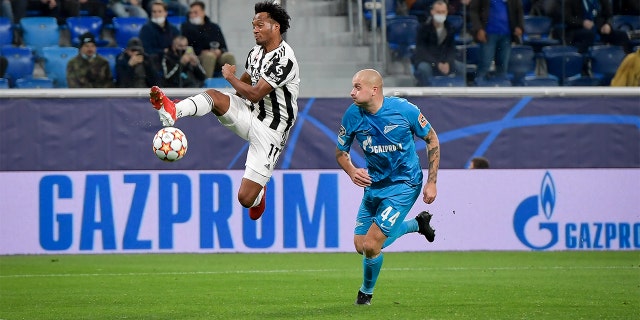 Juan Cuadrado of Juventus in action against Jaroslav Rakitskij of Zenit St. Petersburg during the UEFA Champions League group H match between Zenit St. Petersburg and Juventus at Gazprom Arena on Oct. 20, 2021, in Saint Petersburg, Russia.