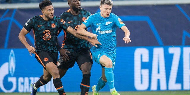 Andrey Mostovoy of Zenit St. Petersburg dribbles past Reece James (left) and Romelu Lukaku (right) of Chelsea FC during the UEFA Champions League group H match between Zenit St. Petersburg and Chelsea FC at Gazprom Arena on Dec. 8, 2021 in Saint Petersburg, Russia.