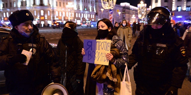 Police officers arrest a protester with a poster saying "I'm against the war" in Moscow, Russia, February 24, 2022, after the Russian attack on Ukraine. 