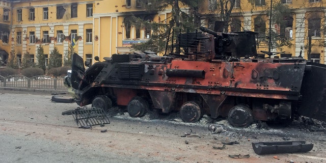 A destroyed armored vehicle is seen in front of a school which, according to local residents, was on fire after shelling, as Russia's invasion of Ukraine continues, in Kharkiv, Ukraine, Feb. 28, 2022.