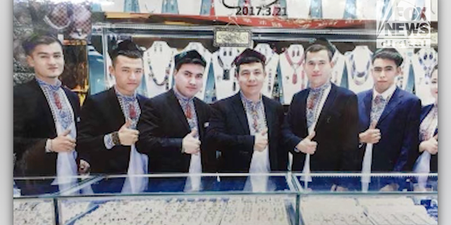 Karim (center) at his old business in Xinjiang.