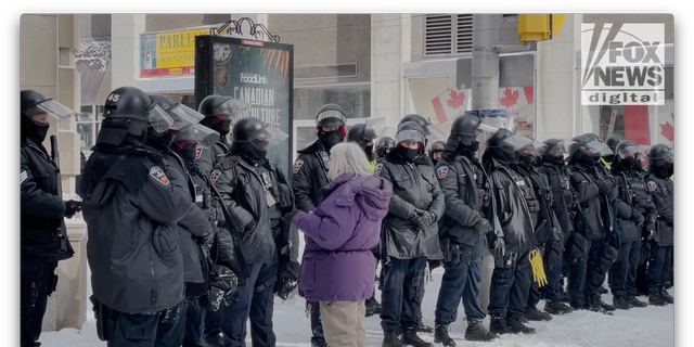 A lady speaks to a line of police officers in downtown Ottawa. (Fox News Digital/Jon Michael Raasch)