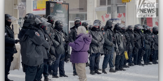 A lady speaks to a line of police officers in downtown Ottawa. (Fox News Digital/Jon Michael Raasch)