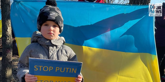 Nikita Borokhnenko holding a sign that reads "Stop Putin. Stop War" during a pro-Ukraine gathering in Metuchen, New Jersey.