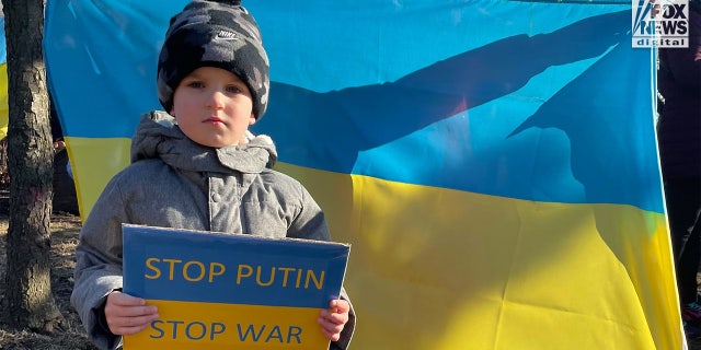 Nikita Borokhnenko holding a sign that reads "Stop Putin. Stop War" during a pro-Ukraine gathering in Metuchen, New Jersey.