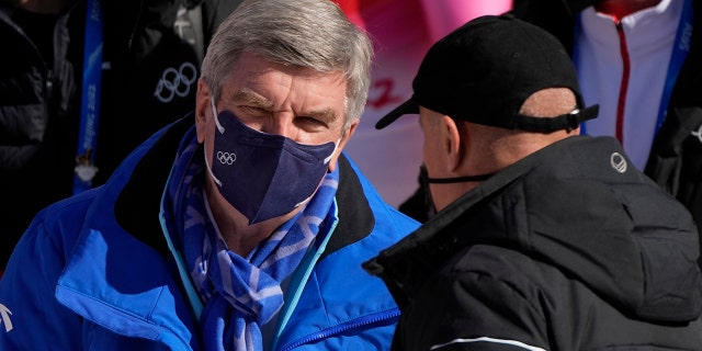 El presidente del Comité Olímpico Internacional, Thomas Bach, a la izquierda, llega a la rampa masculina en los Juegos Olímpicos de Invierno de 2022, el lunes 7 de febrero de 2022, en el distrito de Yanqing de Beijing.