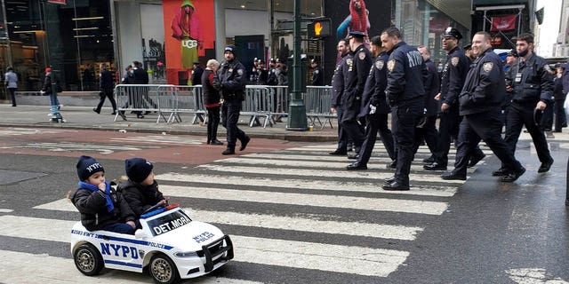 Toddlers at the wheel pay their respects on Wednesday, Feb. 2, 2022, to deceased NYPD Detective Wilbert Mora in midtown Manhattan during his funeral at St. Patrick's Cathedral.