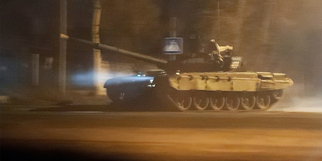 A tank drives along a street after Russian President Vladimir Putin ordered the deployment of Russian troops to two breakaway regions in eastern Ukraine following the recognition of their independence, in the separatist-controlled city of Donetsk, Ukraine, Feb. 22, 2022. 