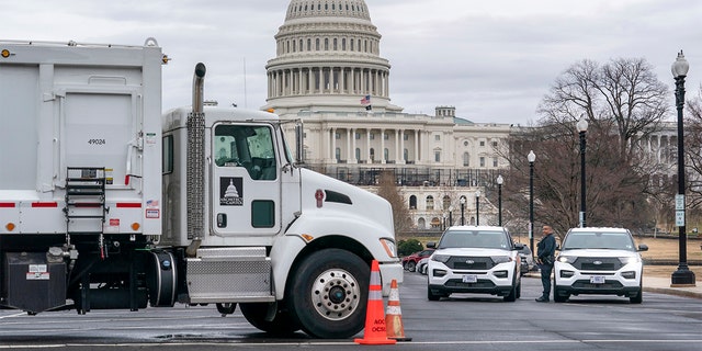 Heavy vehicles, including garbage trucks and snow plows, are set near the entrance to Capitol Hill at Pennsylvania Avenue and 3rd Street NW in Washington, Tuesday, Feb. 22, 2022.