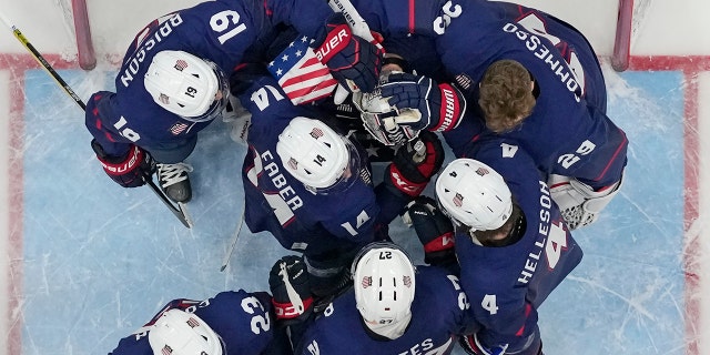 United States players console goalie Strauss Mann after losing to Slovakia 3-2 in a shootout in a men's quarterfinal hockey game at the 2022 Winter Olympics Feb. 16, 2022, in Beijing.
