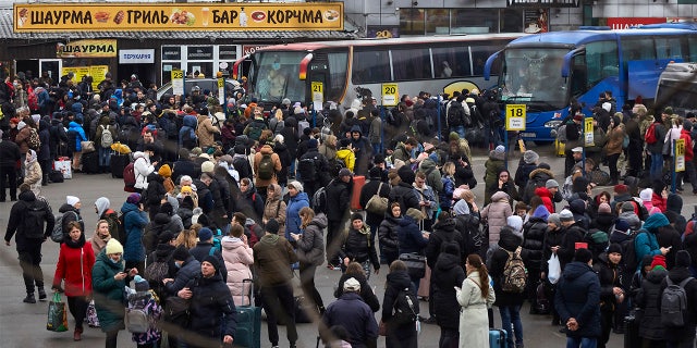 People wait for buses at a bus station as they attempt to evacuate the city Feb. 24, 2022, in Kyiv, Ukraine. Overnight, Russia began a large-scale attack on Ukraine, with explosions reported in multiple cities and far outside the restive eastern regions held by Russian-backed rebels.