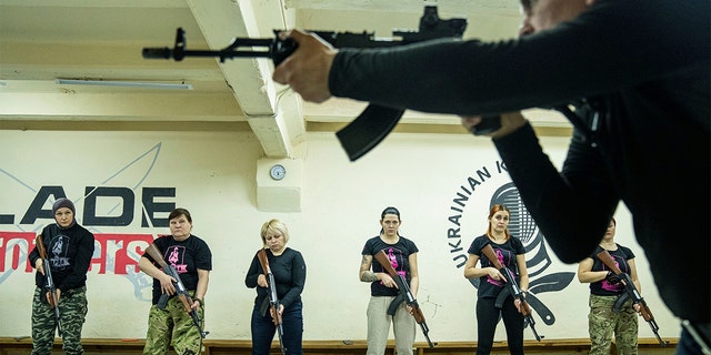 An instructor shows how to use weapons to a group of women during training in Kharkiv, Ukraine, Sunday, Jan. 30, 2022. Some people in Ukraine's second-largest city are preparing to fight back if Russia invades. Kharkiv is just 25 miles from some of the tens of thousands of Russian troops massed at the border.