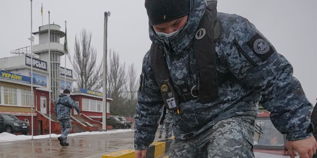 A Ukrainian marine border guard walks on the deck of a boat after a patrol in the Sea of Azov, waters near Mariupol, Donetsk region, in eastern Ukraine, Wednesday, Feb. 2, 2022. 