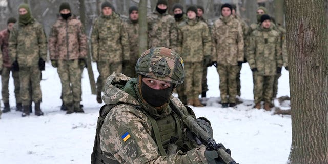 An instructor trains members of Ukraine's Territorial Defense Forces, volunteer military units of the Armed Forces, in a city park in Kyiv, Ukraine, Saturday, Jan. 22, 2022. Dozens of civilians have been joining Ukraine's army reserves in recent weeks amid fears about Russian invasion. 