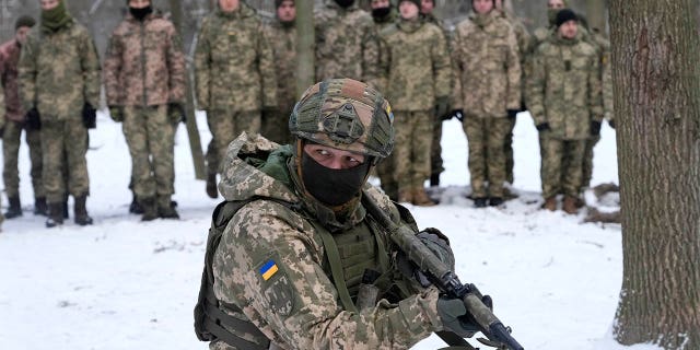 An instructor trains members of Ukraine's Territorial Defense Forces, volunteer military units of the Armed Forces, in a city park in Kyiv, Ukraine, Saturday, Jan. 22, 2022. Dozens of civilians have been joining Ukraine's army reserves in recent weeks amid fears about Russian invasion.