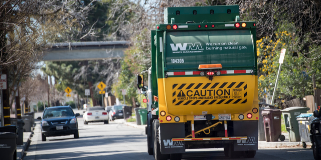 A Waste Management Inc. garbage collection truck drives through a neighborhood in Hayward, California, U.S., Monday, Feb. 12, 2018. 
