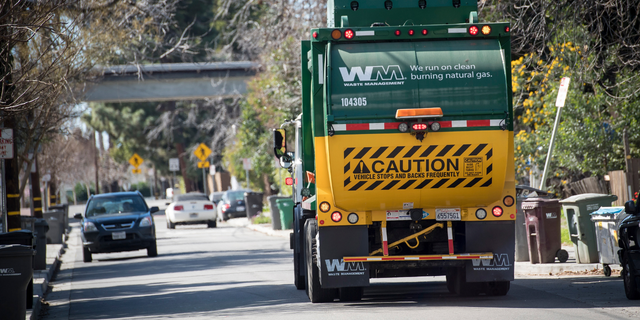 A Waste Management Inc. garbage collection truck drives through a neighborhood in Hayward, California, U.S., on Monday, Feb. 12, 2018.