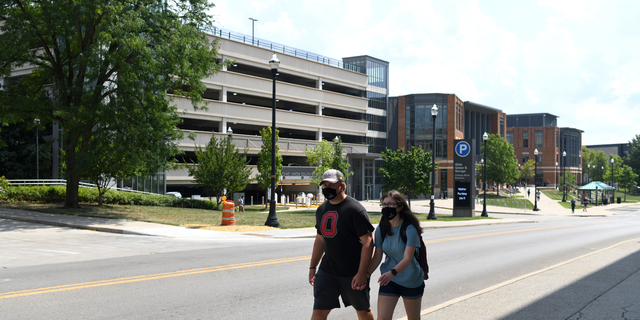 Students wearing protective masks walk through campus during the first of classes at Ohio State University in Columbus, Ohio, U.S., on Tuesday, Aug. 25, 2020.