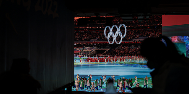 The People's Republic of China march into the National Stadium, while an Olympic worker on duty on February 04, 2022 in Beijing, China.