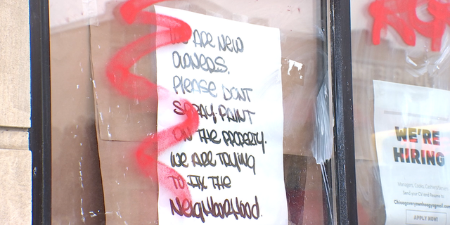 Vandalism is seen in Minneapolis after looting by rioters. The handwritten sign on the window reads, "We are new owners. Please don't spray paint on the property. We are trying to fix the neighborhood."