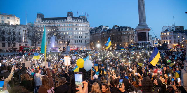 Pro-Ukraine demonstrators hold flags and phone lights as they protest against Russia's invasion of Ukraine in Trafalgar Square, London. 