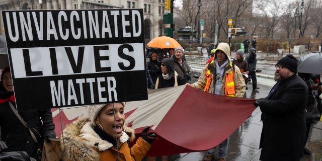 A person holds a sign during the anti-vaccine mandate protest ahead of possible termination of New York City employees due to their vaccination status, Monday, Feb. 7, 2022, in New York. (AP Photo/Yuki Iwamura, File)