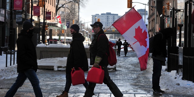 Truckers carry jerry cans for refueling as truckers continue to protest against Covid-19 vaccination mandates, in Ottawa, Canada, February 7, 2022.