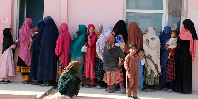 Niños de Afganistán con sus madres el 16 de enero de 2022 en Kabul, Afganistán.  En Afganistán, los niños no pueden mantenerse en pie a pesar de su edad;  La razón es el hambre.  (Foto de Syed Kothaiberti Sadat / Agencia Anatolia a través de Getty Images)