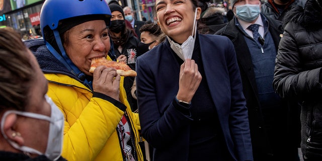 Rep. Alexandria Ocasio-Cortez joins delivery workers to celebrate the passage of legislation by the New York City Council guaranteeing them basic labor rights such as wages, tips, and rest areas, January 23, 2022 in Times Square, New York City. (Photo by Andrew Lichtenstein/Corbis via Getty Images)
