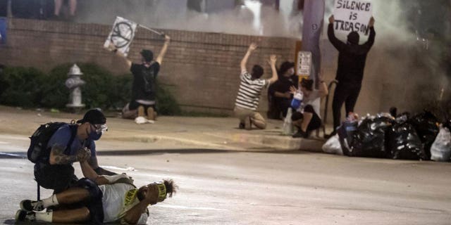 In this May 30, 2020 file photo, people help a protester after he was shot with a rubber bullet under Interstate 35 freeway in Austin Texas while protesting the death of George Floyd.