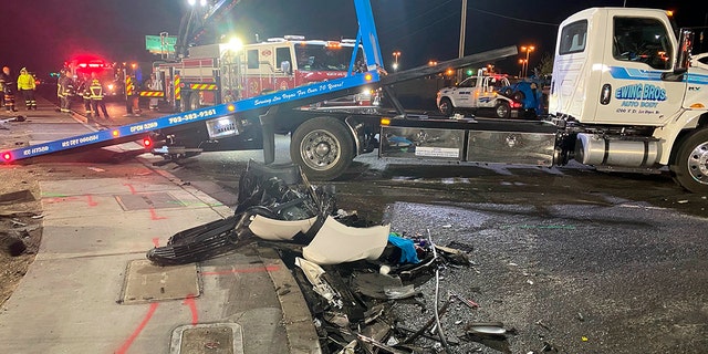 Authorities get set to tow a vehicle involved a six-car crash at the scene of a fatal crash in North Las Vegas, Sunday, Jan. 30, 2022. 