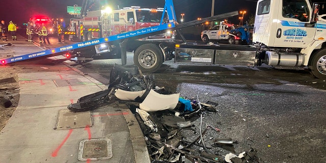 Authorities get set to tow a vehicle involved a six-car crash at the scene of a fatal crash in North Las Vegas, Sunday, Jan. 30, 2022. 