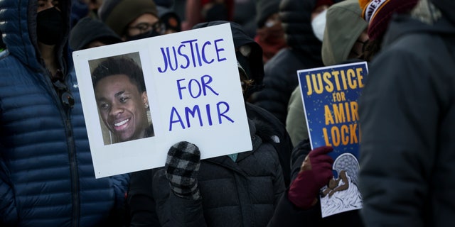 A protester holds a sign demanding justice for Amir Locke at a rally on Saturday, Feb. 5, 2022, in Minneapolis.