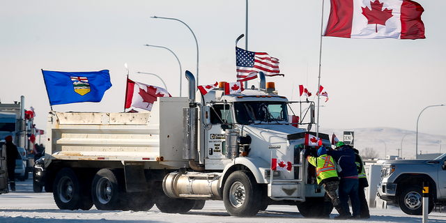 Drivers work to move a gravel truck after a breakthrough resolved the impasse where anti-COVID-19 vaccine mandate demonstrators blocked the highway at the busy U.S. border crossing in Coutts, Alberta, Wednesday, Feb. 2, 2022. 