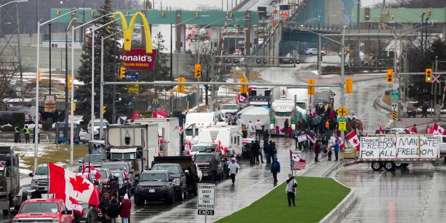 Truckers and supporters block the access leading from the Ambassador Bridge, linking Detroit and Windsor, as truckers and their supporters continue to protest against COVID-19 vaccine mandates and restrictions, in Windsor, Ontario, Friday, Feb. 11, 2022. (Associated Press)