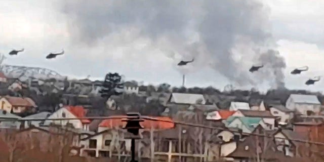 In this handout photo taken from video released by Ukrainian Police Department Press Service, Military helicopters apparently Russian, fly over the outskirts of Kyiv, Ukraine, Thursday, Feb. 24, 2022.