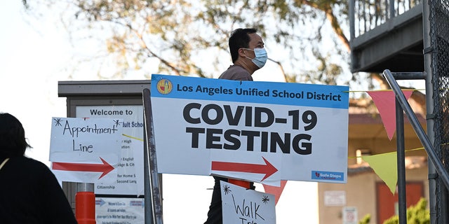People line up for Covid-19 screening at a testing and vaccination site at a public school in Los Angeles, California, January 5, 2022. (Photo by ROBYN BECK / AFP via Getty Images)