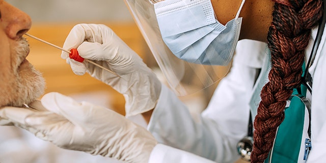 A doctor conducts a coronavirus test. 