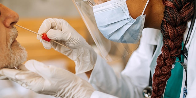 A doctor conducts a coronavirus test.