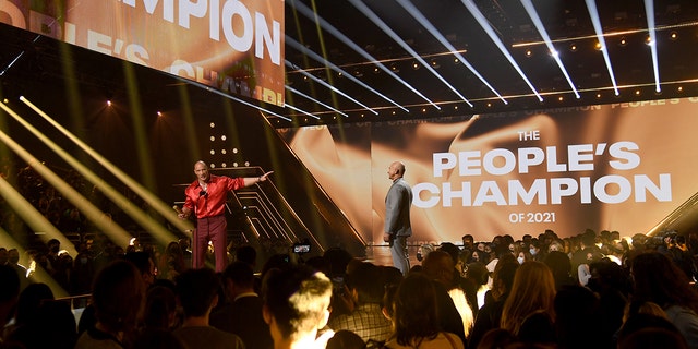  (L-R) Honoree Dwayne Johnson accepts The People’s Champion of 2021 award from Jeff Bezos onstage during the 2021 People's Choice Awards.