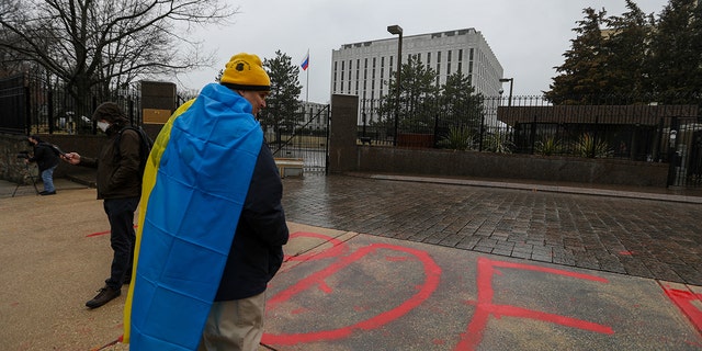 WASHINGTON, DC - FEBRUARY 24: Protesters gather in front of the Russia's Embassy in Washington to protest against Russian intervention in Ukraine, as a woman writes "murder" in front of the embassy building on February 24, 2022 in Washington, United States.