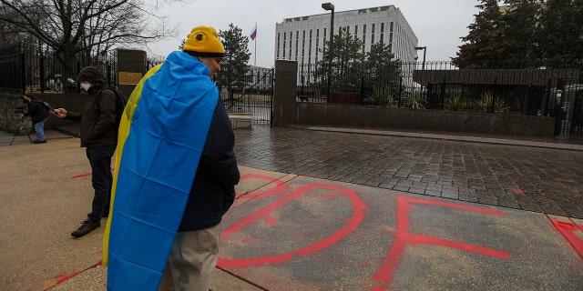 WASHINGTON, DC - FEBRUARY 24: Protesters gather in front of the Russia's Embassy in Washington to protest against Russian intervention in Ukraine, as a woman writes "murder" in front of the embassy building on February 24, 2022 in Washington, United States.